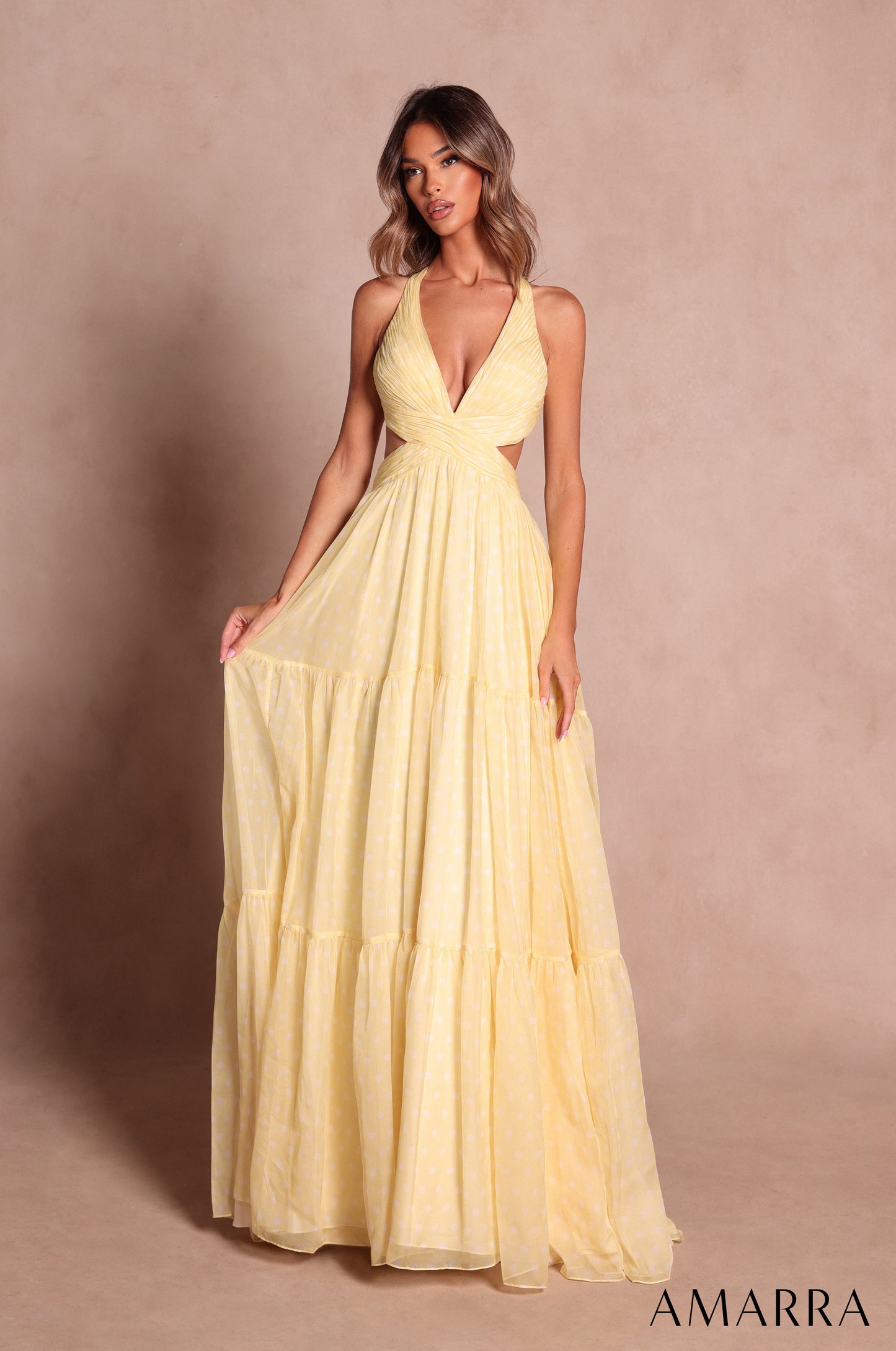 Amarra style 89730 long light yellow polka dot dress with subtle white dots, plunging halter neckline, cutout sides and three-tiered a-line skirt, front view